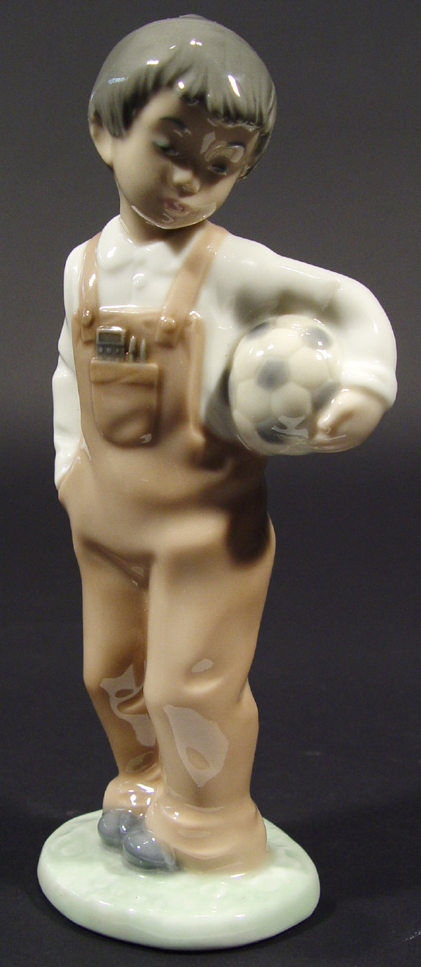 Appraisal: Nao porcelain figure of a boy clutching a football with