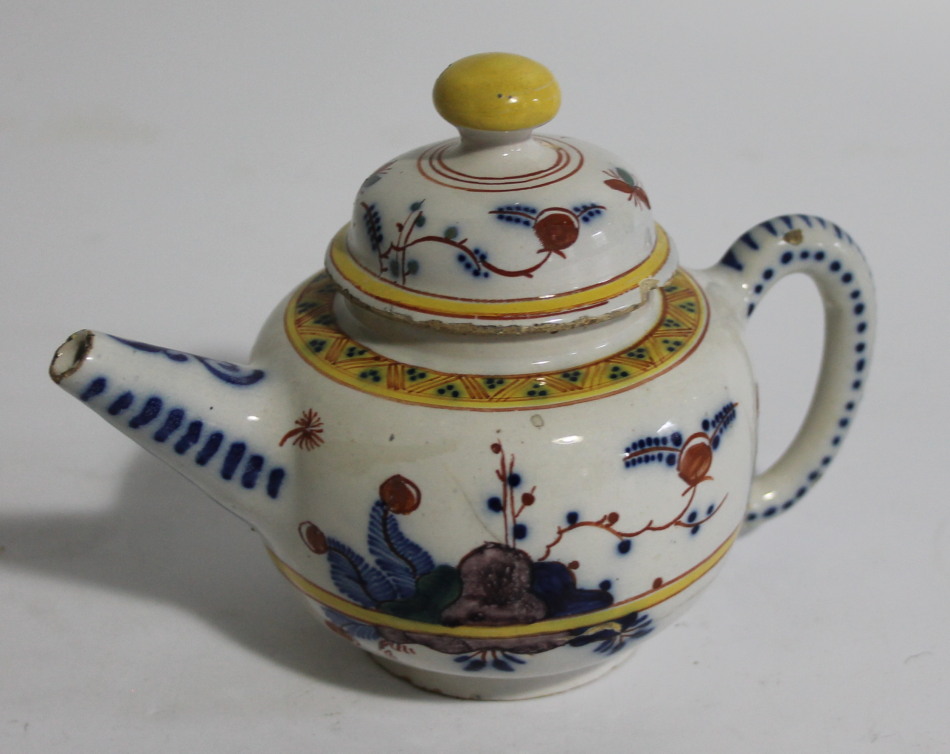 Appraisal: A tin glazed earthenware teapot the compressed circular body with