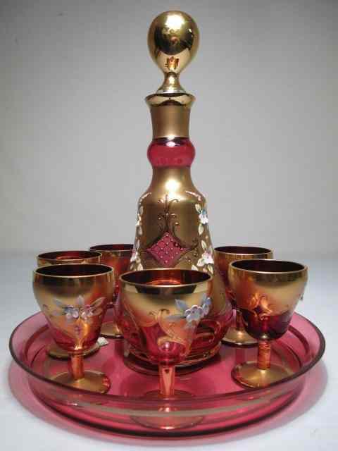 Appraisal: Gold gilt and floral enameled cranberry decanter set with matching