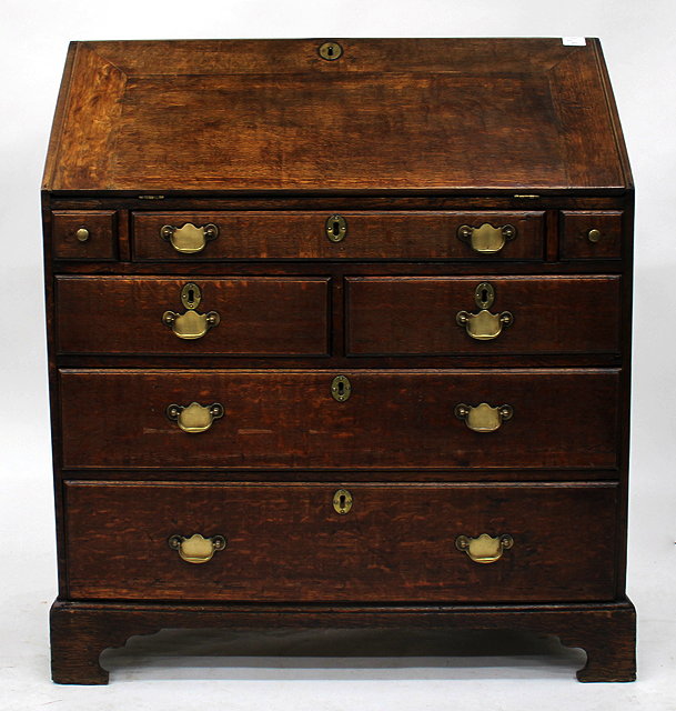 Appraisal: A TH CENTURY OAK BUREAU having five drawers brass handles