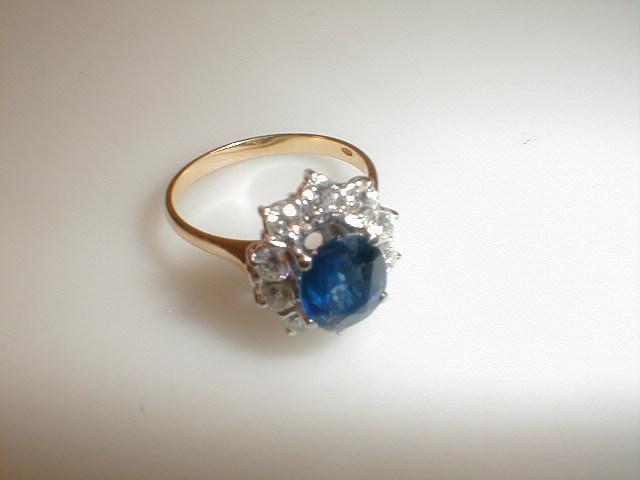 Appraisal: A diamond cluster ring with a sapphire blue central stone