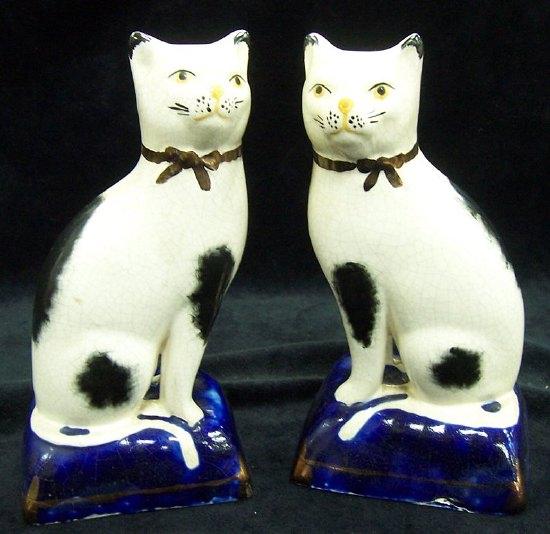 Appraisal: A pair of Staffordshire cats on blue cushion boxes cm