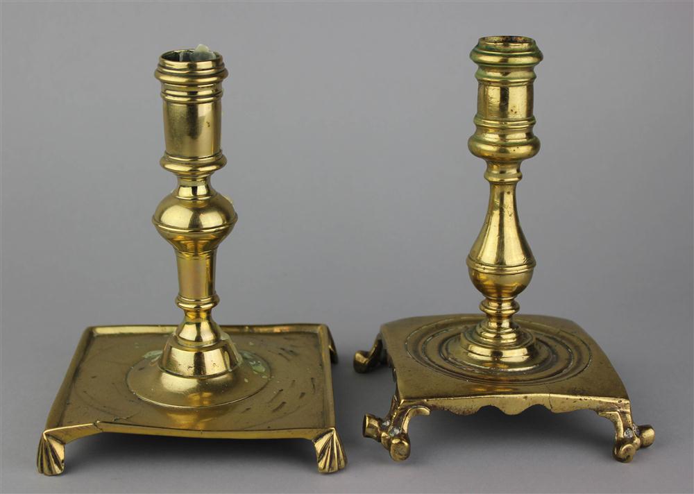 Appraisal: TWO CONTINENTAL BRASS CANDLESTICKS ON FOOTED BASES one with bulbous