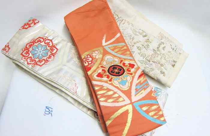 Appraisal: THREE JAPANESE SILK OBIS various patterns each of repeating designs