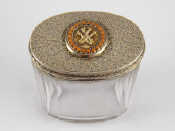 Appraisal: A silver mounted panelled oval glass jar the lid ornately