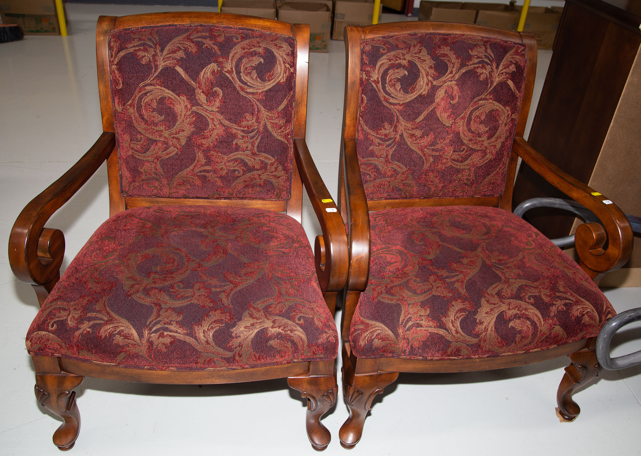 Appraisal: A PAIR OF UPHOLSTERED CHAIRS With wooden scroll arms in