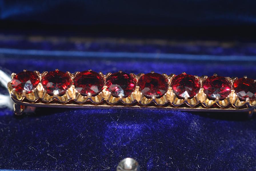 Appraisal: A GARNET BAR BROOCH IN CT GOLD A GARNET BAR