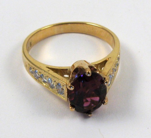 Appraisal: RHODOLITE GARNET AND DIAMOND RING centering an oval-cut rhodolite garnet