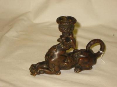 Appraisal: A RENAISSANCE STYLE BRONZE CANDLESTICK cast as a recumbant mythical