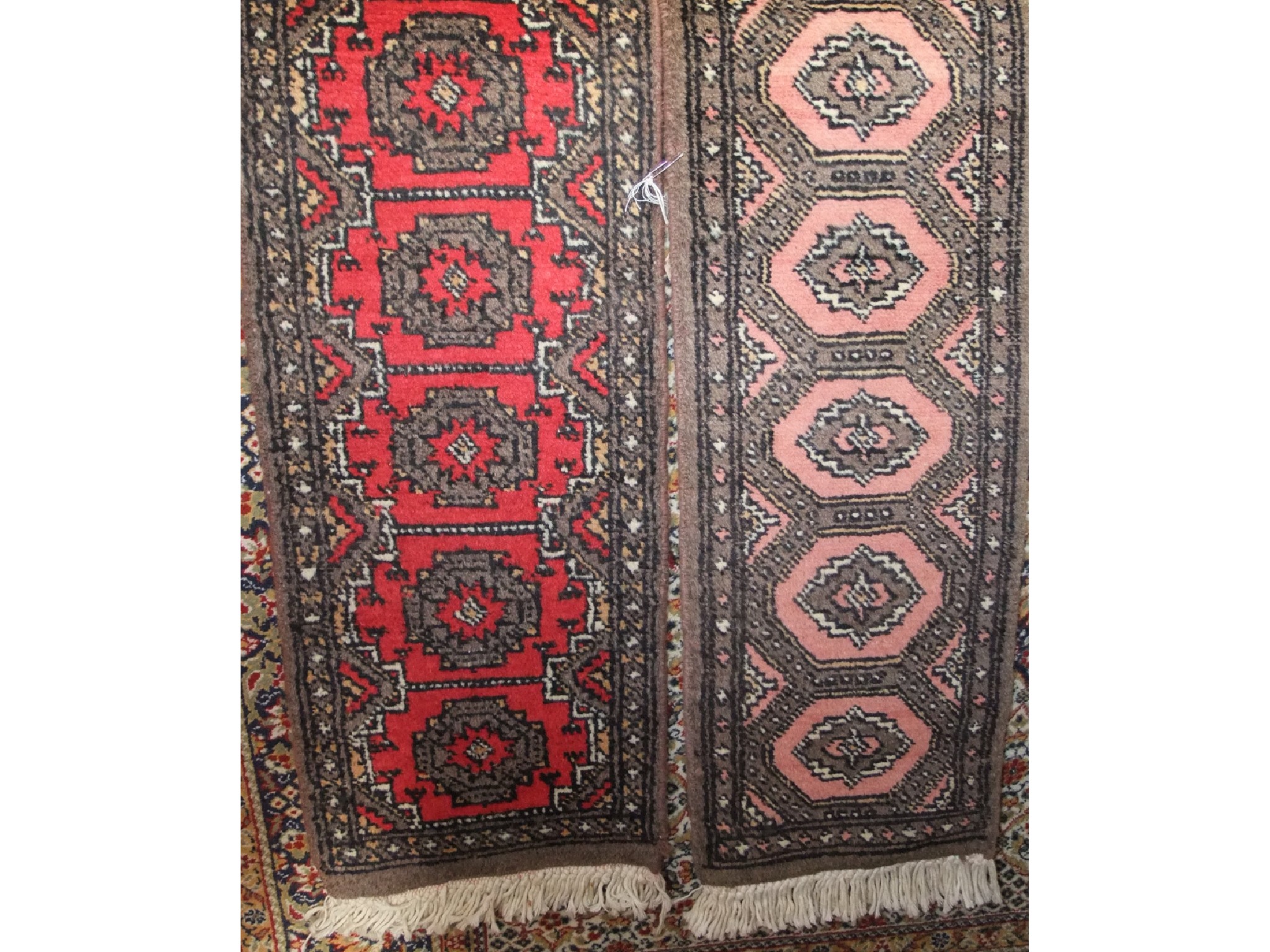 Appraisal: A miniature eastern wool work runner with red central field