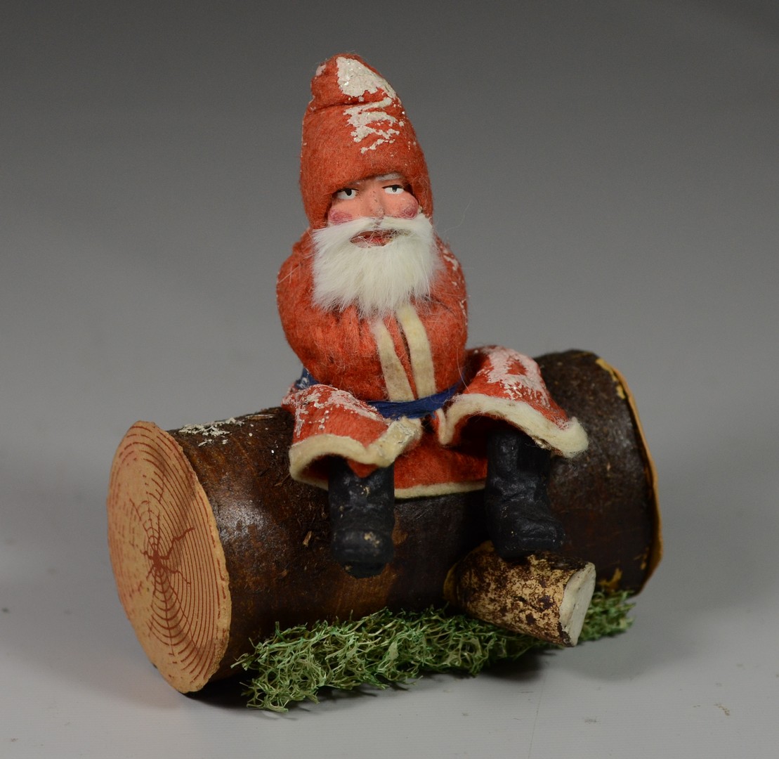 Appraisal: Paper paper mache Santa sitting on log candy container German