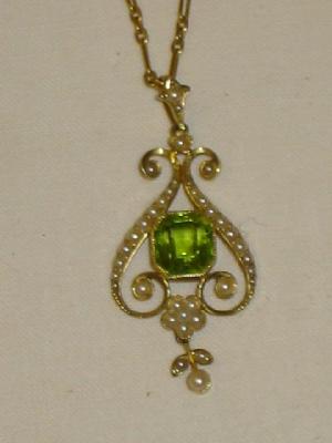 Appraisal: AN EDWARDIAN PERIDOT AND SEED PEARL PENDANT the central emerald