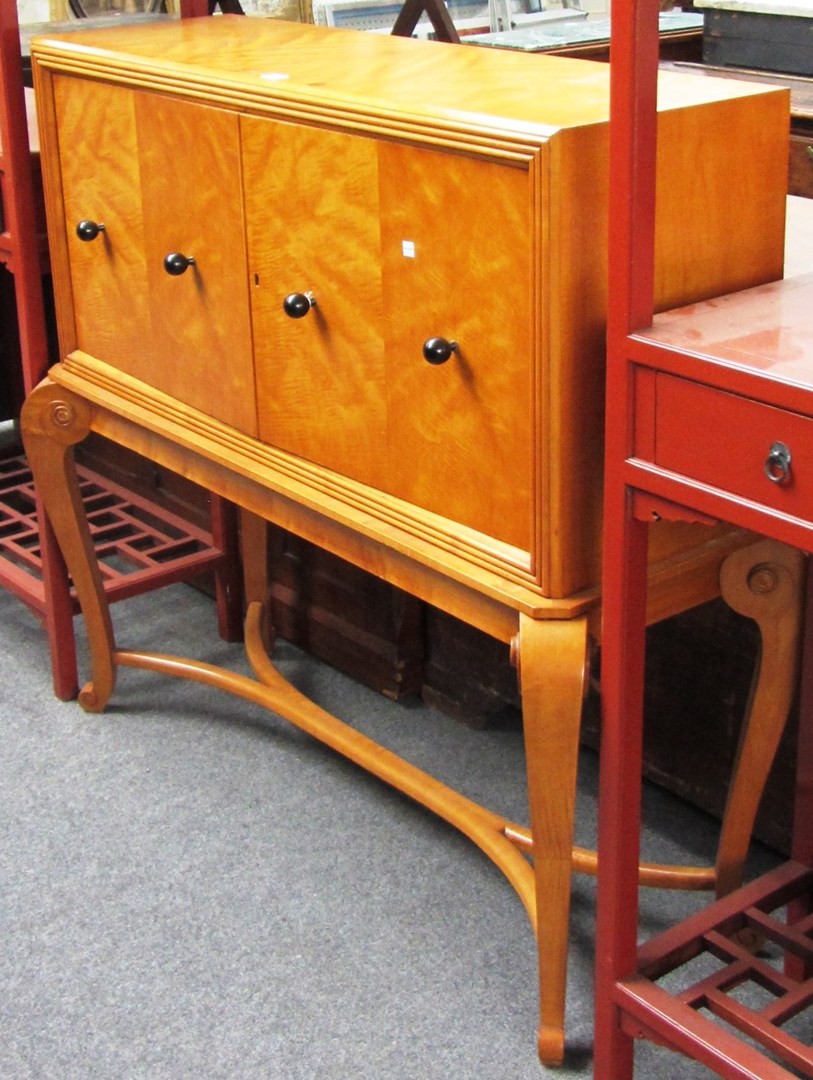 Appraisal: A mid th century maple two door drinks cabinet on