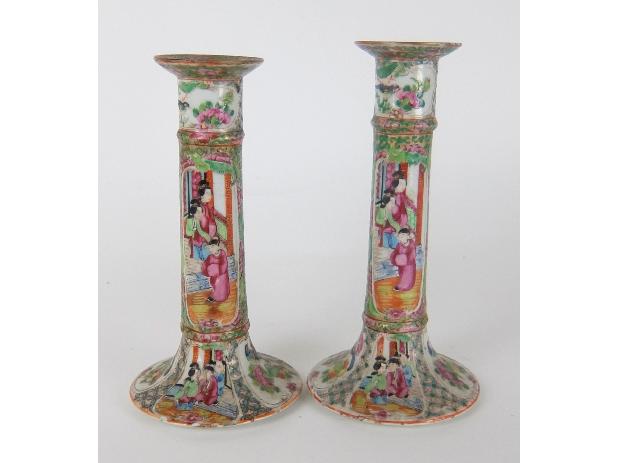 Appraisal: A pair of Cantonese famille rose candlestickspainted with panels of