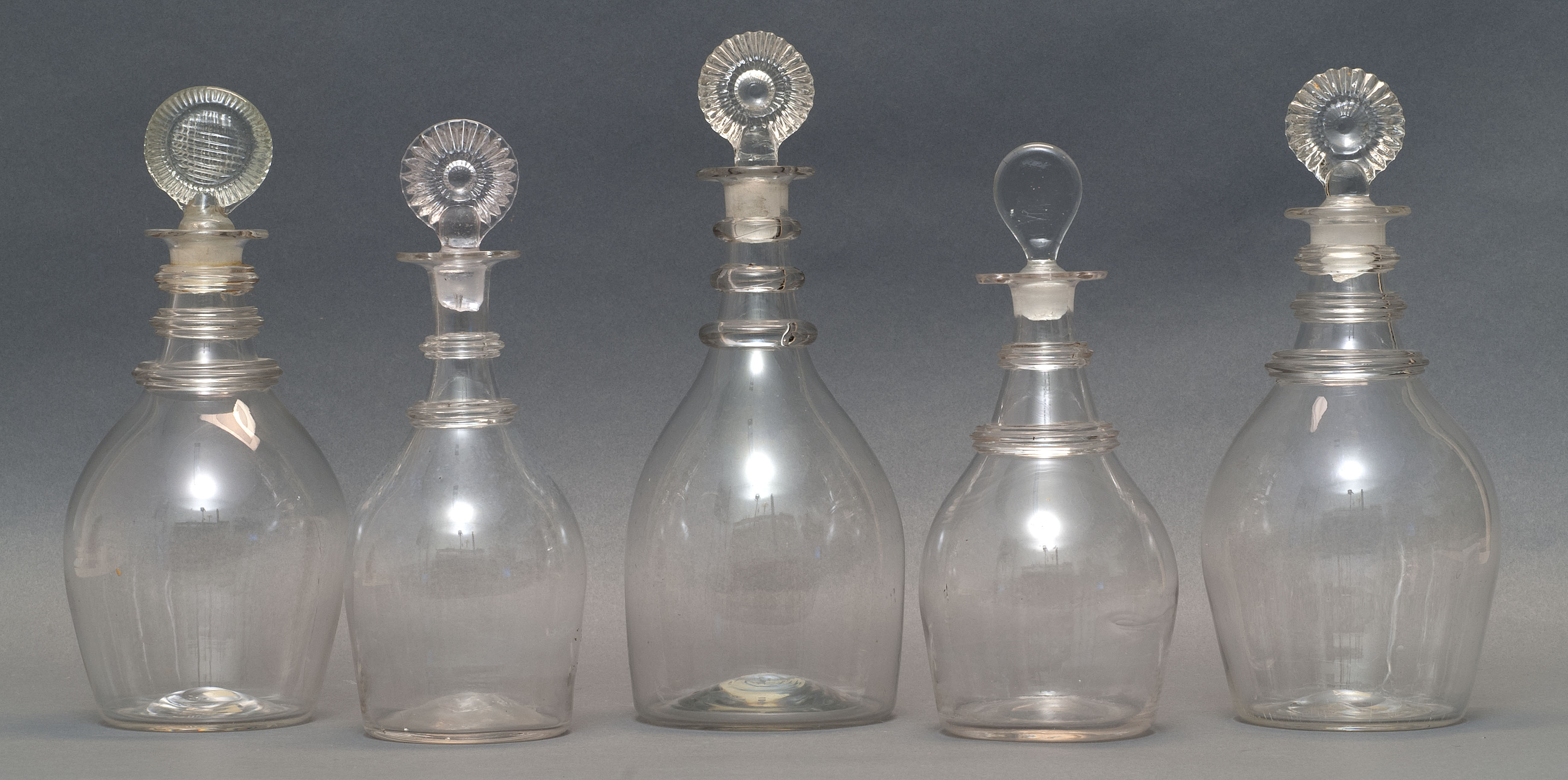 Appraisal: FIVE CLEAR FREE-BLOWN GLASS DECANTERS th CenturyIn varied sizes and