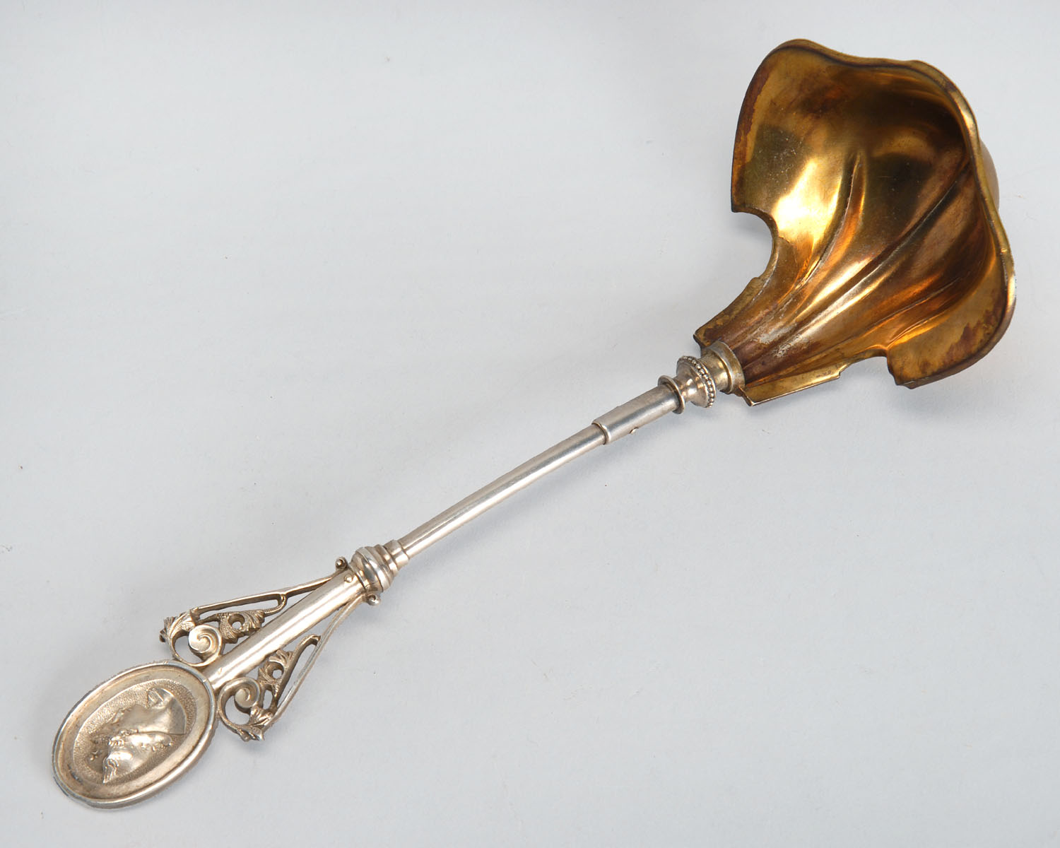 Appraisal: WOOD HUGHES STERLING SILVER LADLE In the Medallion pattern Gold-washed