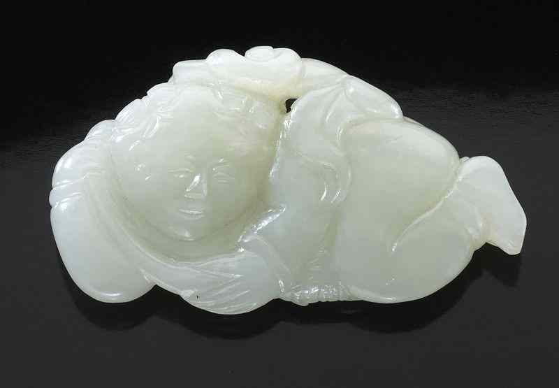 Appraisal: Chinese Qing carved white jade boy with flowers on his