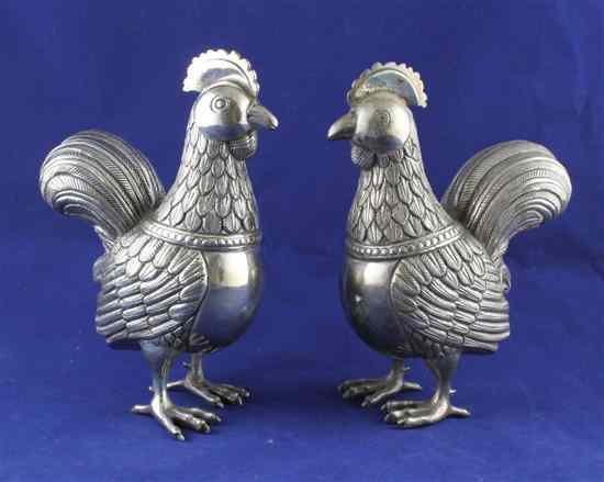 Appraisal: A pair of Indian white metal free standing cockerels with