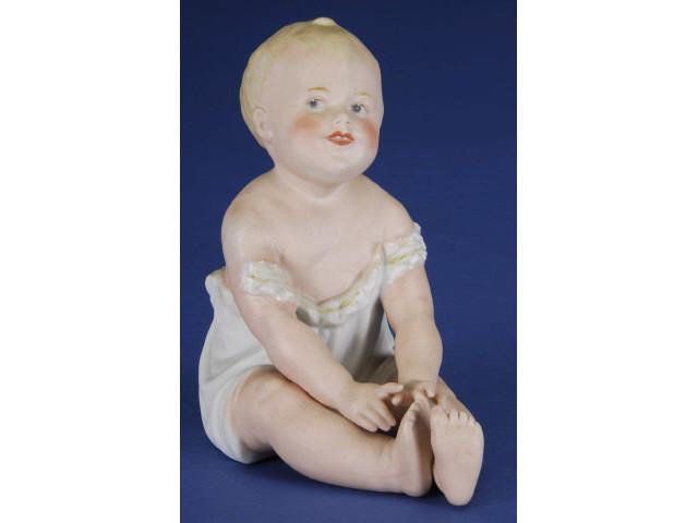 Appraisal: Small Heubach Seated Piano Baby Germany ca bisque seated figurine