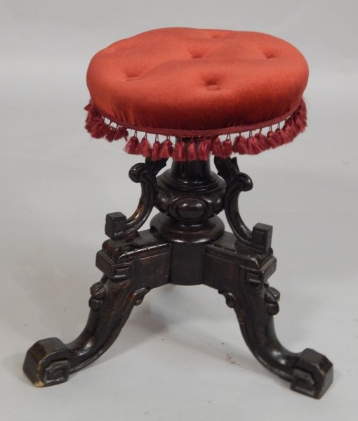 Appraisal: A Victorian ebonised piano stool with a padded seat on