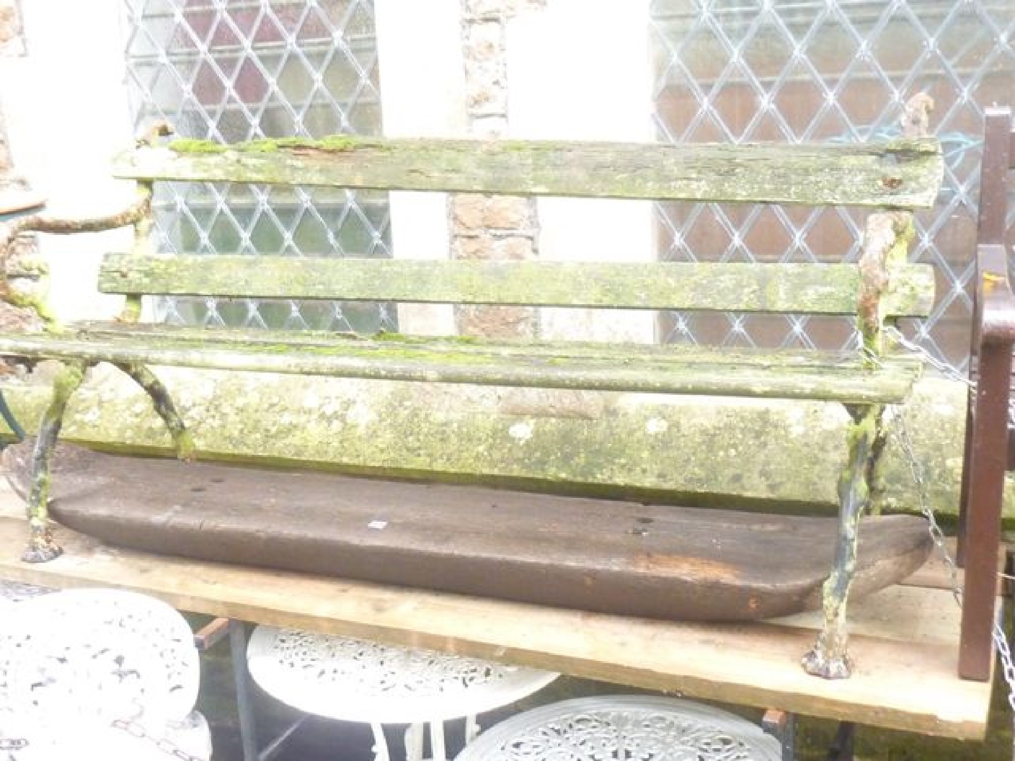 Appraisal: A Victorian three seat garden bench with weathered timber slatted