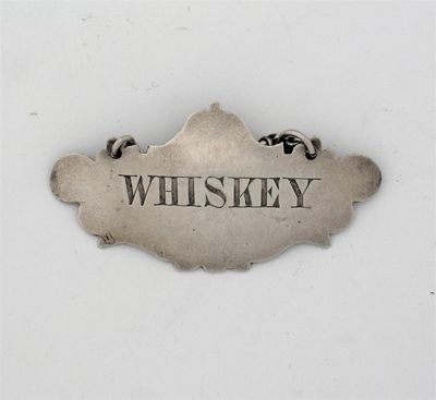 Appraisal: A Victorian escutcheon wine label incised 'WHISKEY' by George Unite