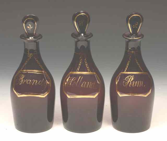 Appraisal: A SET OF THREE AMETHYST GLASS DECANTERS AND STOPPERS of