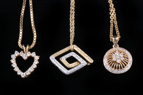 Appraisal: THREE GOLD AND DIAMOND PENDANTS ON K YELLOW GOLD CHAINS