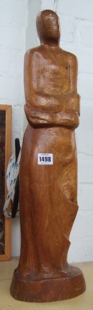 Appraisal: A contemporary wooden carving modelled as a stylized figure clutching