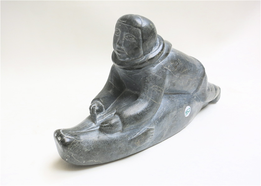 Appraisal: CANADIAN STONE CARVING OF AN INUIT HUNTER skinning a seal