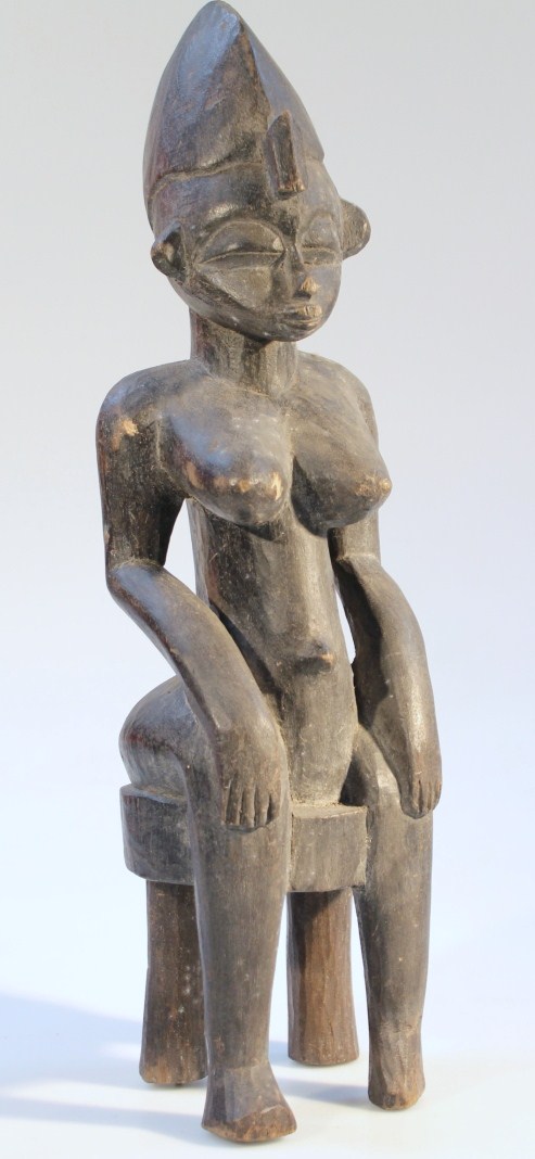 Appraisal: A thC carved African tribal figure of a lady seated