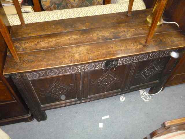 Appraisal: AN OLD OAK COFFER with triple panelled chip carved front