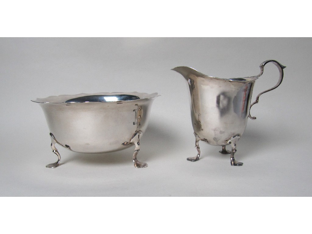 Appraisal: A silver sugar bowl and cream jug on trefoil feet