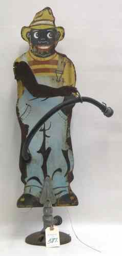 Appraisal: A COLLECTIBLE TIN PAINTED BLACK MAN SPRINKLER with short hose