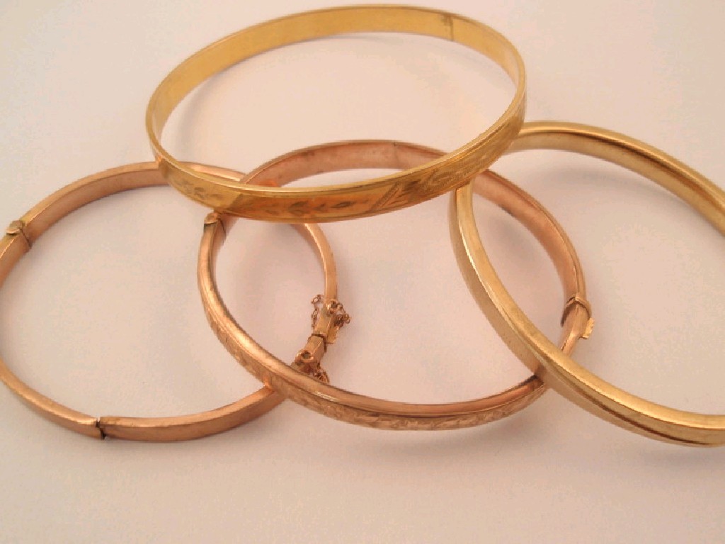 Appraisal: Three gold bangles AF g and a rolled gold example