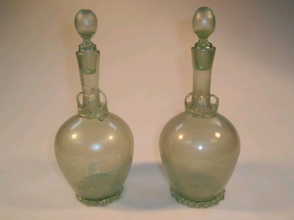 Appraisal: A pair of Venetian iridescent green tinted ovoid decanters and