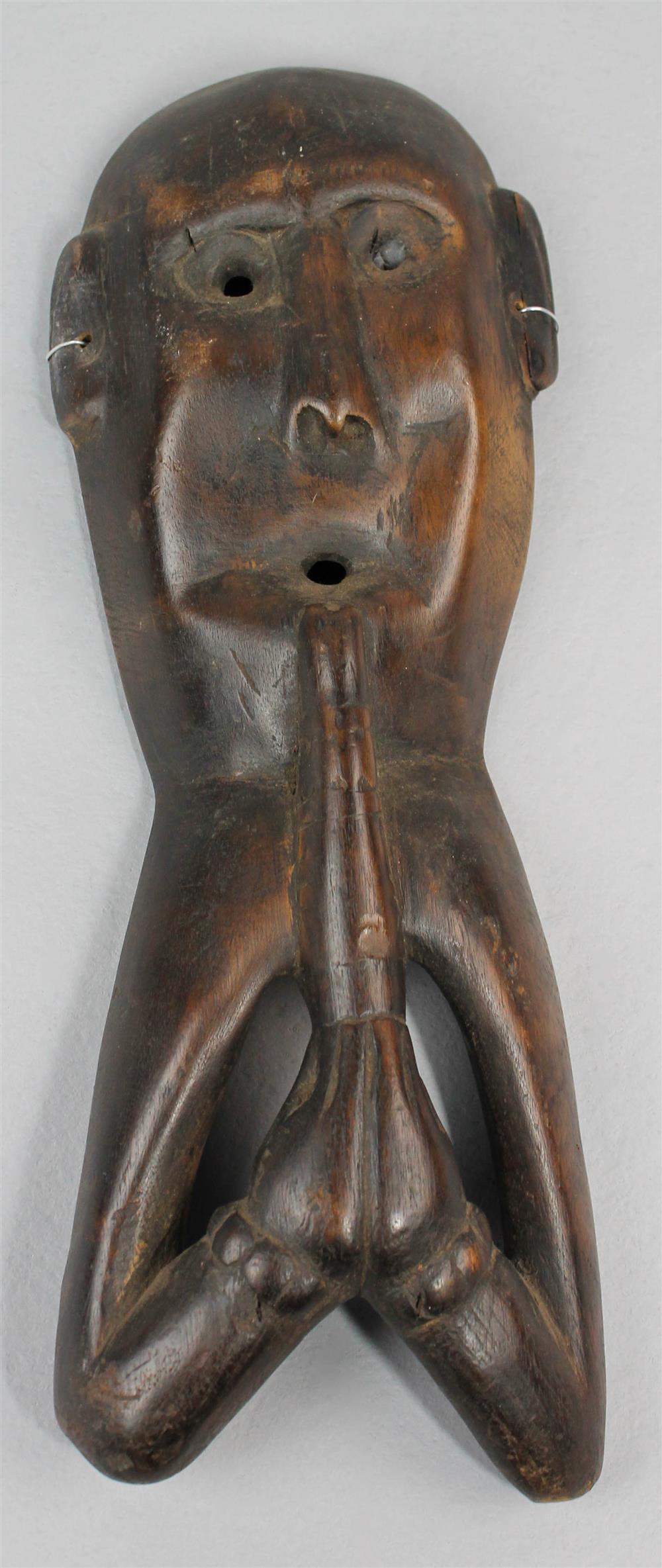 Appraisal: AFRICA CARVED MASK OF A FIGURE PLAYING AN INSTRUMENT having