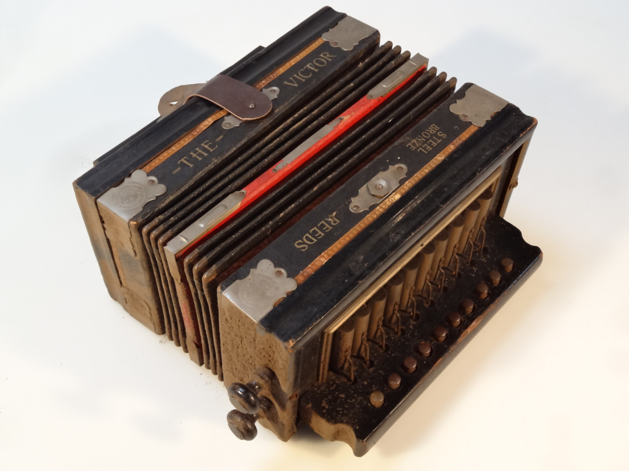 Appraisal: An early thC Saxony Victor accordion squeezebox with ebonised wooden