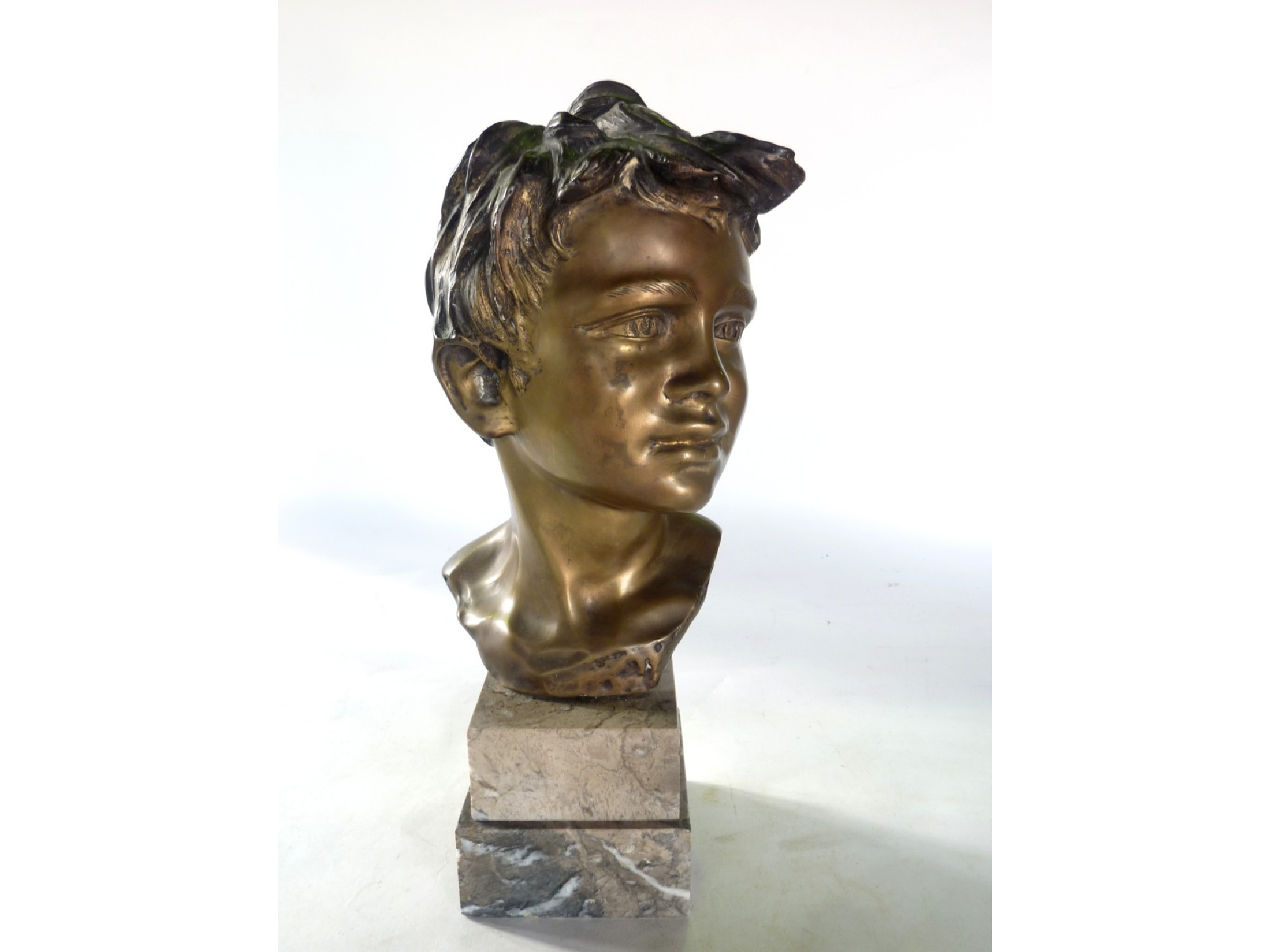 Appraisal: A cast bronze head of a young boy signed to