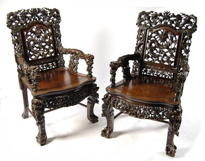 Appraisal: A pair of Chinese carved hardwood open armchairs decorated dragons