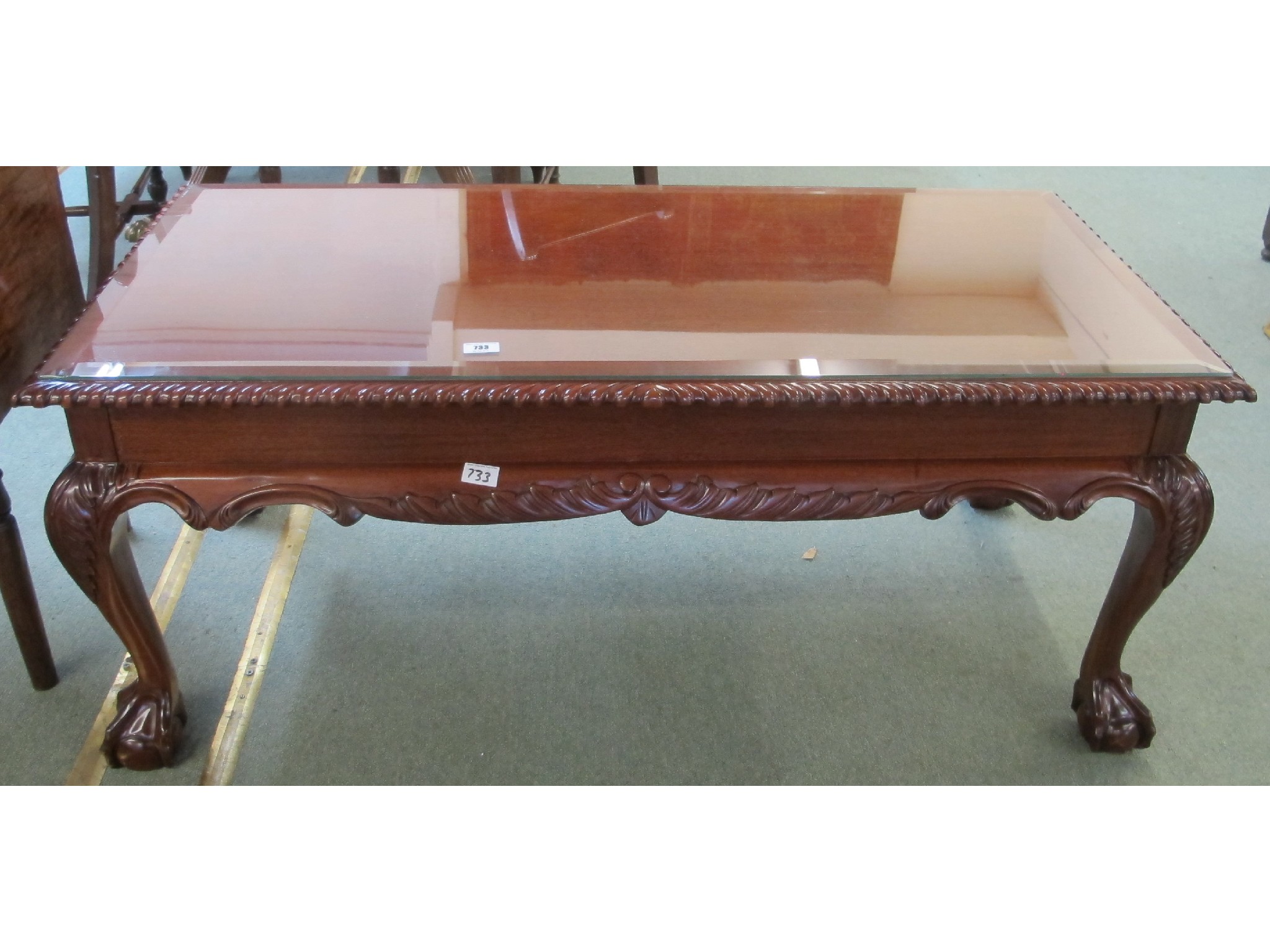 Appraisal: A contemporary mahogany coffee table with ball and claw feet