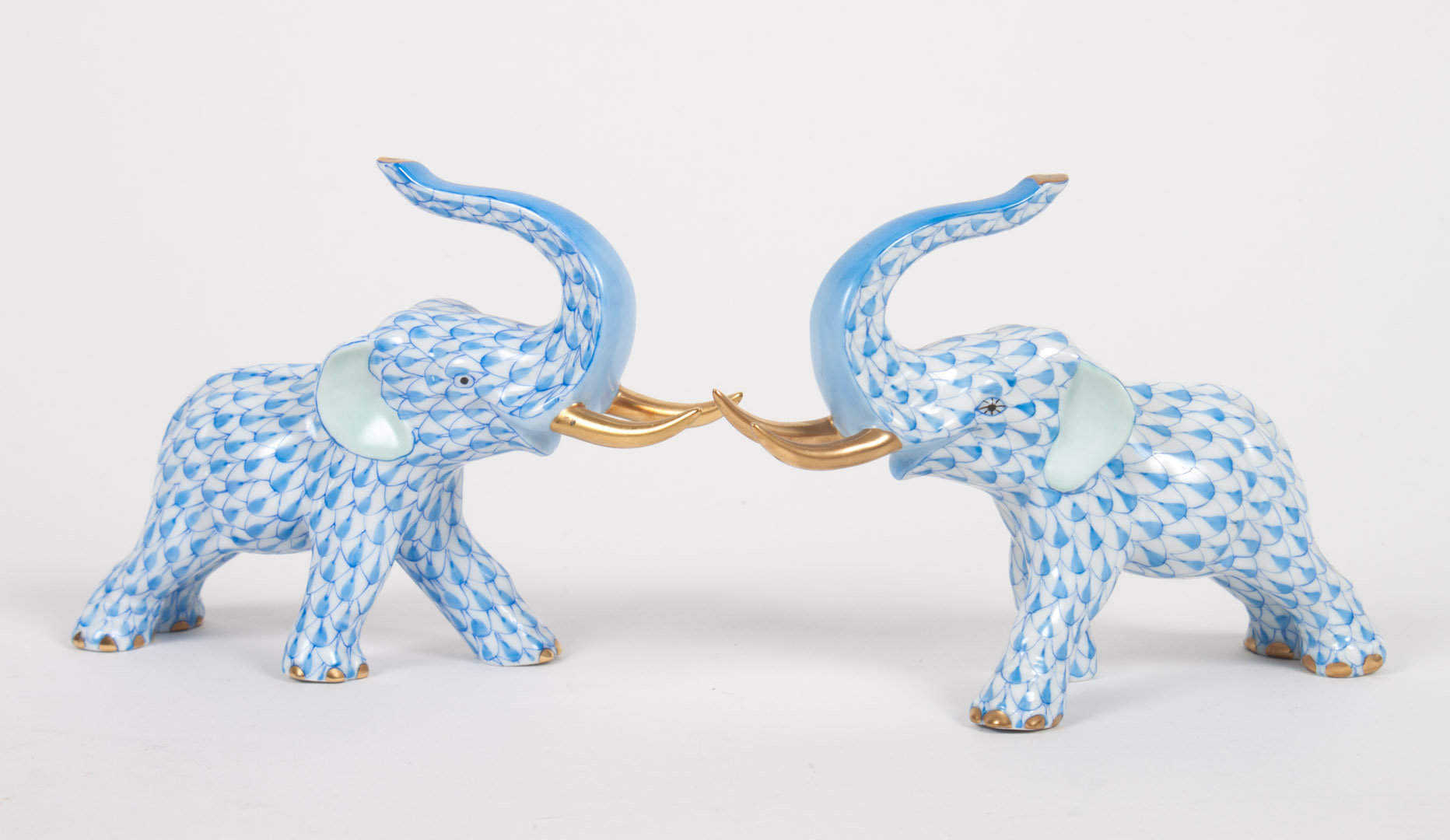 Appraisal: Pair of Herend porcelain elephants blue fishnet pattern parcel-gilt highlights