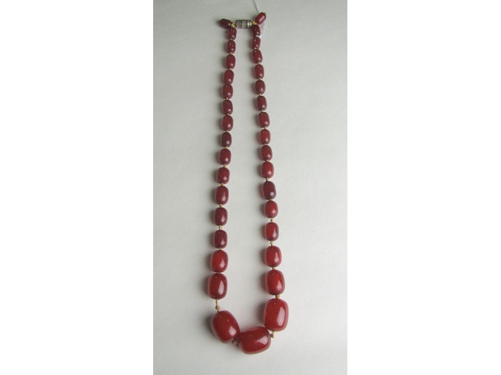 Appraisal: String of red amber beads Approximately inches