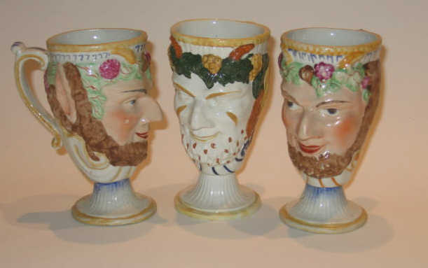 Appraisal: THREE STAFFORDSHIRE CREAMWARE SATYR CUPS Each polychrome decorated molded as