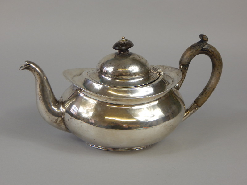 Appraisal: An English white metal teapot of oval form with ebonised