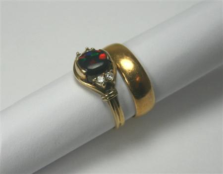 Appraisal: A black opal and diamond set ring the central claw