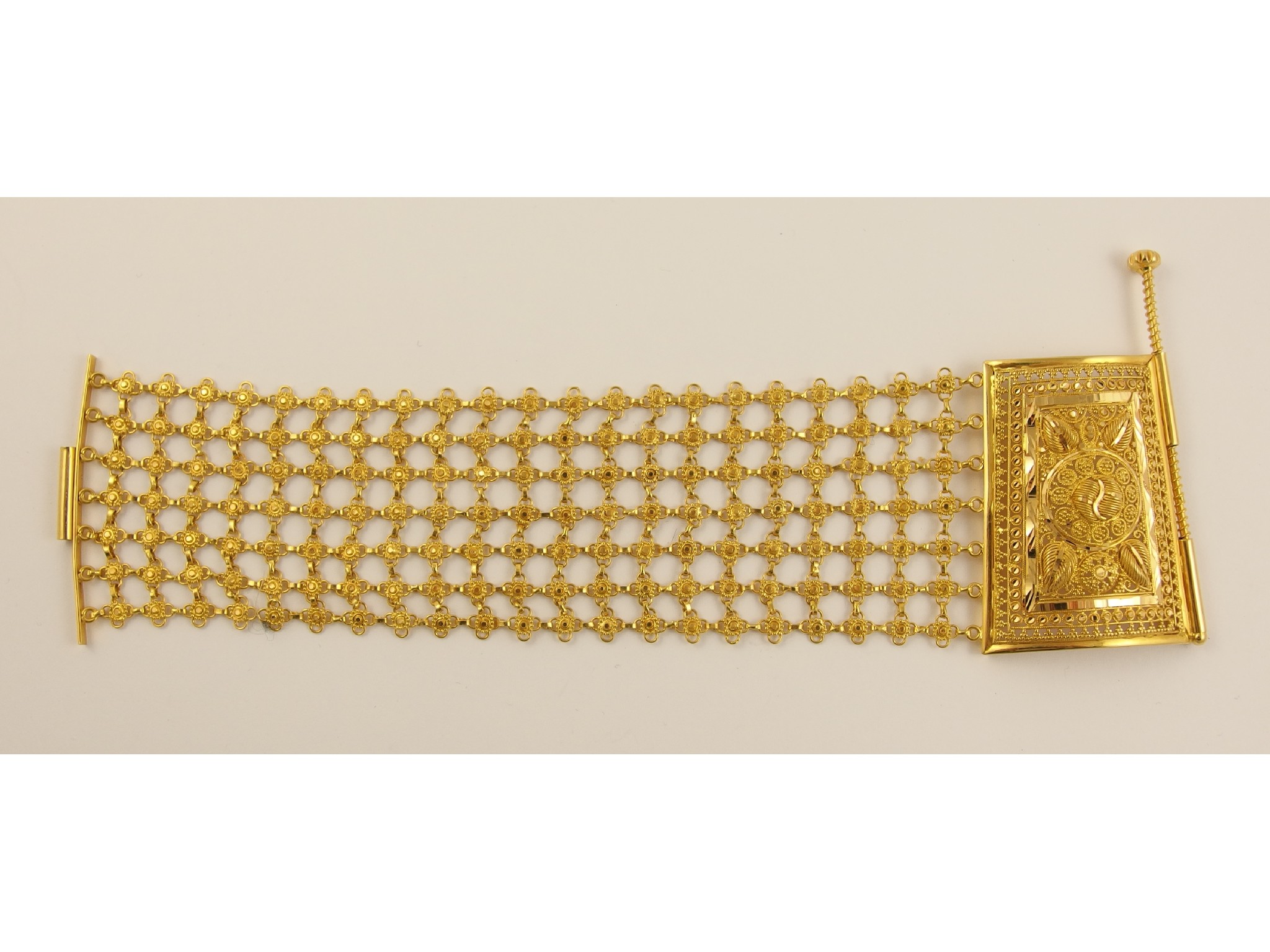 Appraisal: A ct wide cuff braceletwith a filigree flower motif mesh