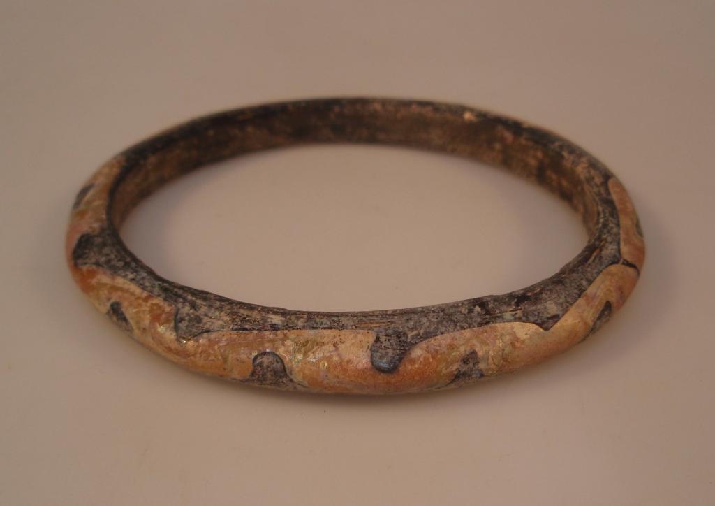 Appraisal: A large Islamic glass bangle appearing black decorated with a