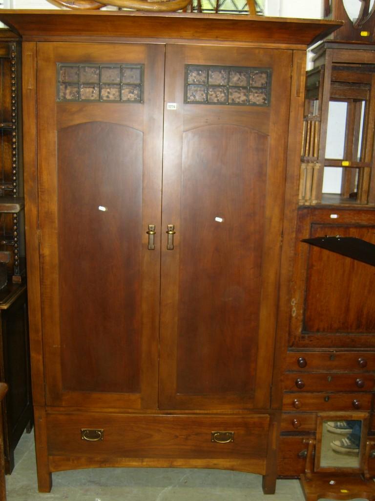 Appraisal: An American Arts Crafts style wardrobe enclosed by a pair