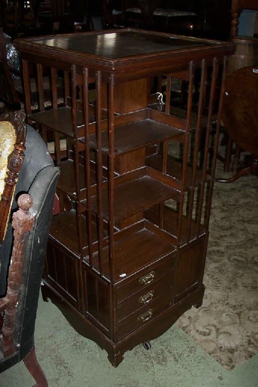 Appraisal: An Edwardian walnut floor standing revolving bookcase of square cut